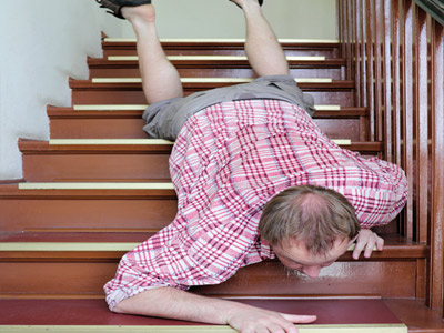 Ein Mann rutscht auf einer Treppe herunter.